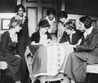 Description 1920 photo Sewing stars on suffrage flag