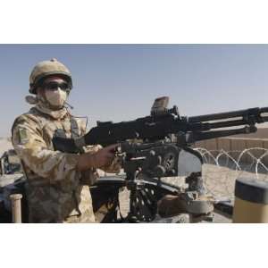  A British Army soldier mans a machine gun mounted on top 