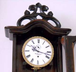 the clock showing the pendulum bob with the door open